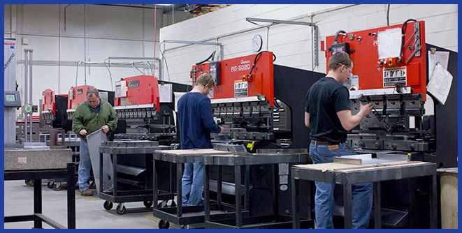 Sheet metal forming equipment operators working.